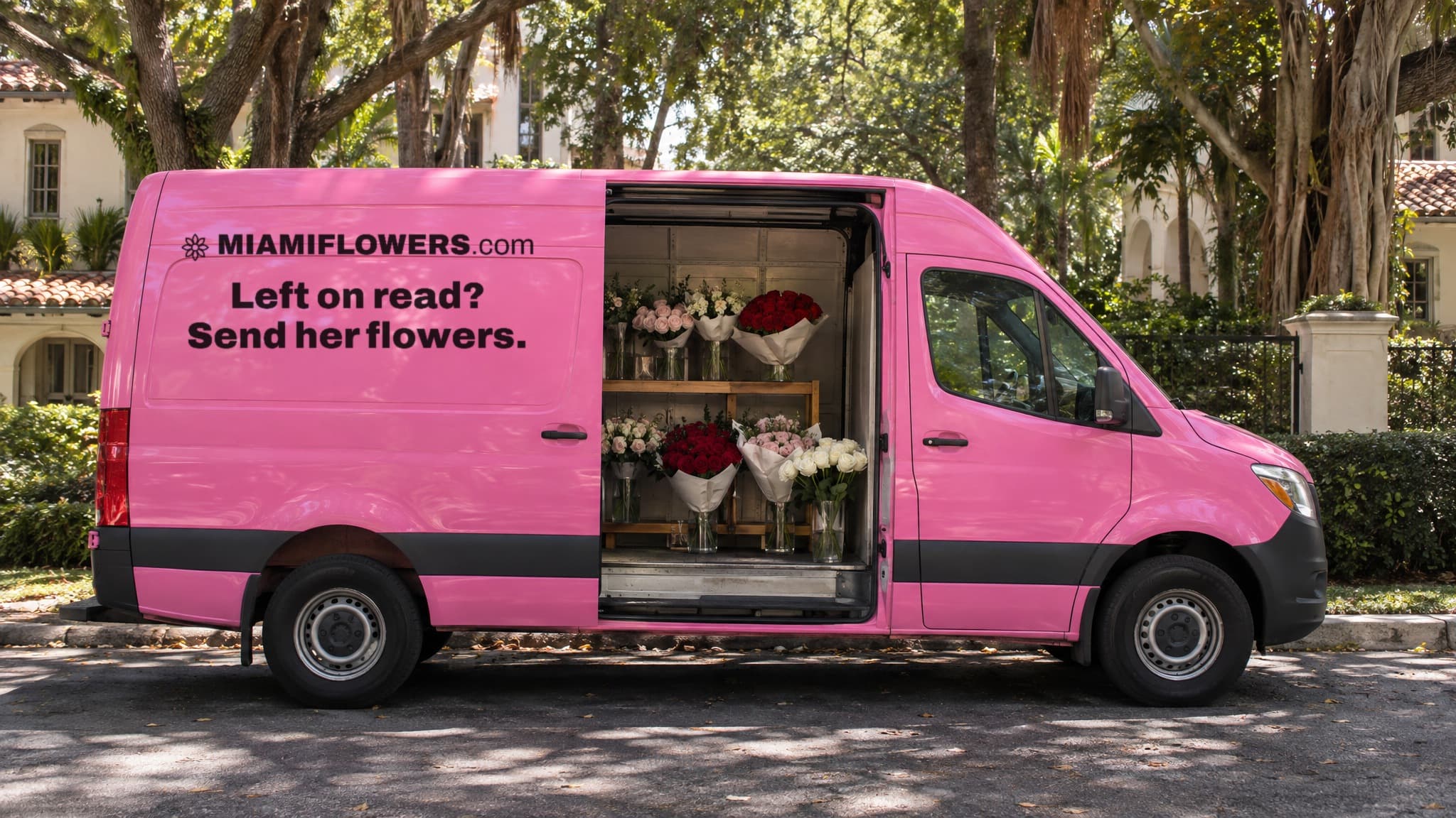 A pink MIAMIFLOWERS.com Sprinter van with its side door open, shelves inside lined with wrapped rose bouquets