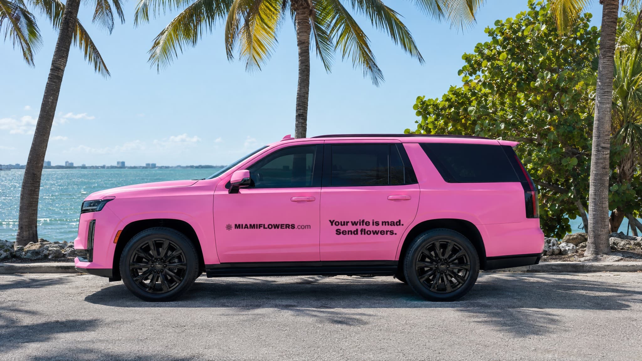 Pink MIAMIFLOWERS.com Escalade reading 'Your wife is mad. Send flowers.'