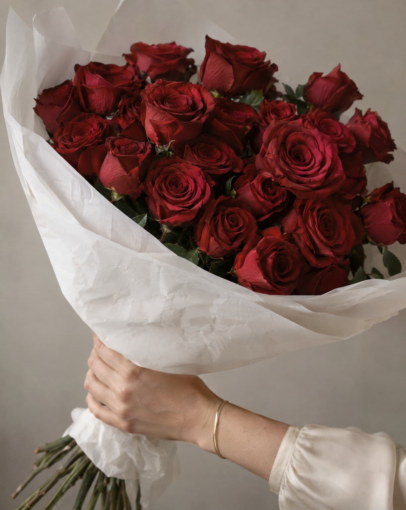 A hand holding a bouquet of roses